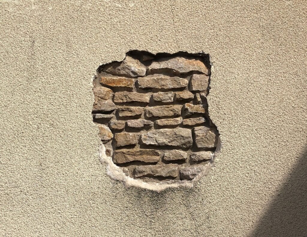 Una sección expuesta de una pared de ladrillo en Bourgogne-Franche-Comté, mostrando textura rústica.
