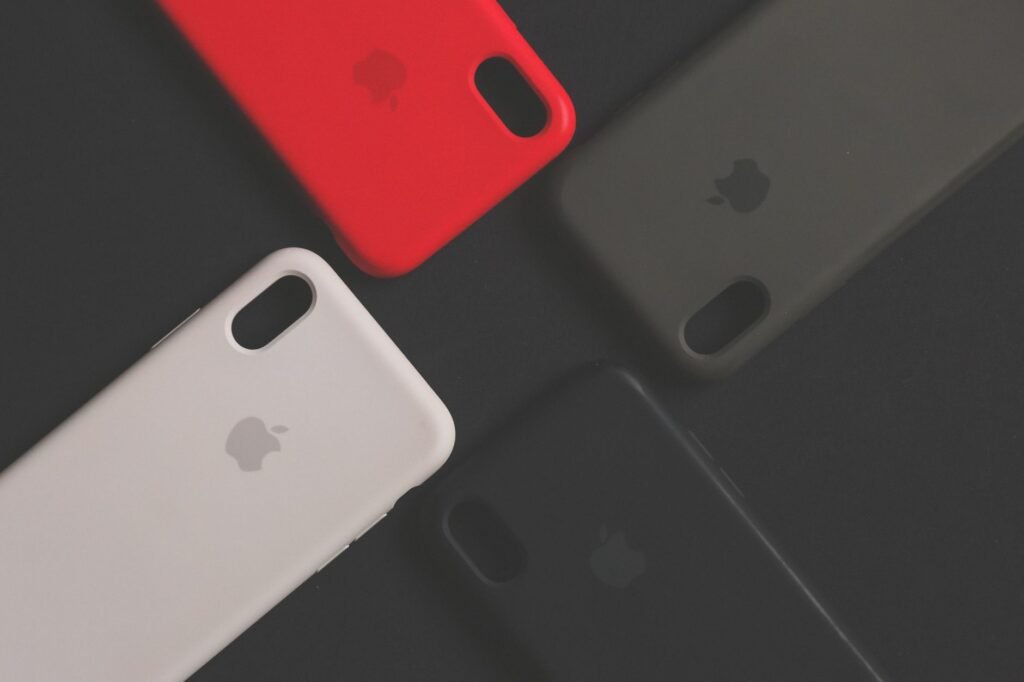 Cuatro fundas de smartphone coloridas sobre una superficie oscura, mostrando variedad y diseño.