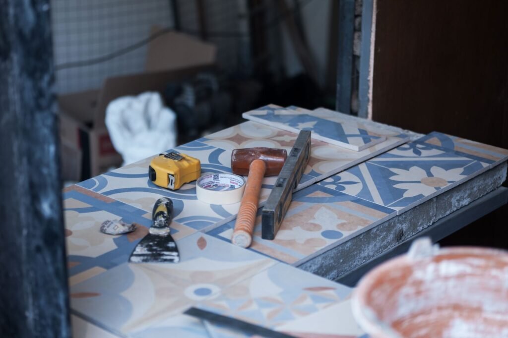 Herramientas y azulejos en un sitio de construcción, listos para el trabajo de azulejos. Incluye paleta, cinta métrica y cinta adhesiva.