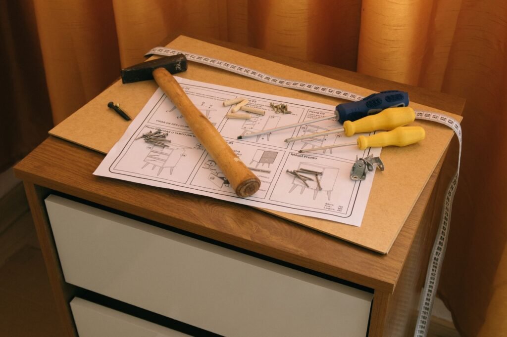 Vista cenital de ensamblaje de muebles DIY con herramientas e instrucciones sobre un escritorio de madera.