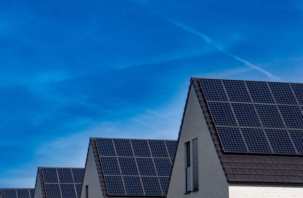 Contemporary homes featuring solar panels under a bright blue sky promoting renewable energy.