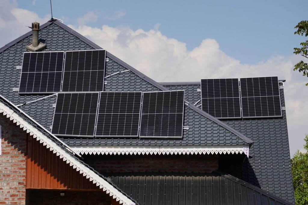 Rooftop solar panels on a house in Srinagar against a blue sky backdrop.