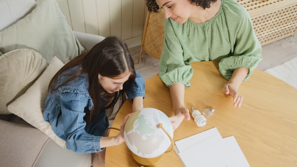 A mother and daughter exploring a globe together at home, promoting education and learning.