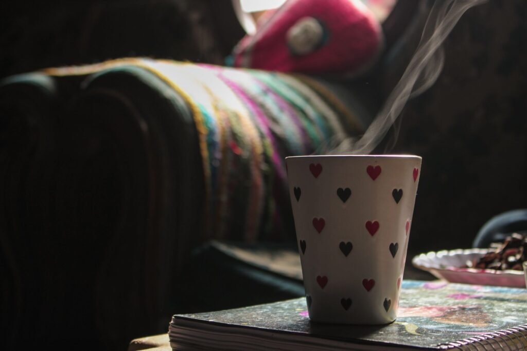 A heart-patterned coffee mug releasing steam in a cozy indoor setting, creating a warm atmosphere.
